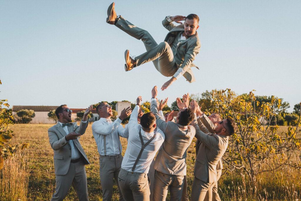 Photo fun des mariés et leurs témoins. Le marié est jetée en l'air par les garçons